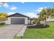 Charming single-Gathering home with a well-manicured lawn, mature landscaping, and a gray two-car garage at 398 Walnut Ct, Palm Harbor, FL 34683
