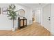 Inviting hallway with wood flooring, modern console table, decor and access to the bathroom at 398 Walnut Ct, Palm Harbor, FL 34683