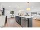 Open kitchen with stainless steel appliances, island with bar seating, and quartz countertops at 398 Walnut Ct, Palm Harbor, FL 34683