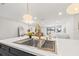 Open-concept kitchen with stainless steel sink in the foreground and an open view to the living room at 398 Walnut Ct, Palm Harbor, FL 34683