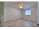 Clean bedroom featuring new gray wood-look floors, fresh paint, a ceiling fan, and a window at 4004 Cortez Dr # D, Tampa, FL 33614