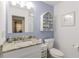 Well-lit bathroom featuring a granite countertop, white vanity and toilet, and a decorative shelf at 401 Dorchester Pl # 55, Sun City Center, FL 33573