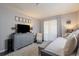 Well-lit bedroom with daybed, upholstered storage bench, decorative pillows, side table, large window, and mounted TV at 401 Dorchester Pl # 55, Sun City Center, FL 33573