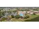 Aerial view of the community pool, sports facilities, and clubhouse set among lush landscaping and a pond at 401 Dorchester Pl # 55, Sun City Center, FL 33573