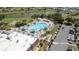 Aerial view of a large community pool with ample lounge seating, umbrellas, and a bocce ball court at 401 Dorchester Pl # 55, Sun City Center, FL 33573