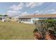 Rear exterior showcasing lush landscaping, a green lawn, and a screened in lanai at 401 Dorchester Pl # 55, Sun City Center, FL 33573