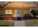Charming yellow home featuring a decorative front door, cozy bench, and inviting, landscaped yard at 401 Dorchester Pl # 55, Sun City Center, FL 33573