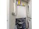 A compact laundry area with stacked washer and dryer units and a wire shelf for storage at 401 Dorchester Pl # 55, Sun City Center, FL 33573