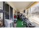 Enclosed sunroom/patio area with artificial turf, various storage items, and access to the outdoors at 401 Dorchester Pl # 55, Sun City Center, FL 33573