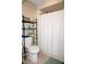 A cozy bathroom has a white toilet, neutral tile floors, and an organizer shelf for storage at 4338 Tahitian Gardens Cir # H, Holiday, FL 34691