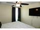 Bedroom with TV, ceiling fan and window with dark curtains at 4338 Tahitian Gardens Cir # H, Holiday, FL 34691