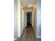 Hallway with laminate flooring leads to bedrooms and bathrooms. Neutral walls and trim add to the clean aesthetic at 4338 Tahitian Gardens Cir # H, Holiday, FL 34691