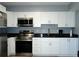 Bright kitchen with stainless steel appliances, granite countertops, and white cabinetry at 4338 Tahitian Gardens Cir # H, Holiday, FL 34691