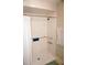 An all-white shower features tile, a shower curtain, and grab bars for safety and accessibility at 4338 Tahitian Gardens Cir # H, Holiday, FL 34691