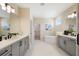 Expansive bathroom featuring dual vanities, a soaking tub, and a walk-in closet for added luxury at 4405 W Euclid Ave, Tampa, FL 33629