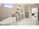 Bright bathroom features a soaking tub, elegant tile work, and modern fixtures under natural lighting at 4405 W Euclid Ave, Tampa, FL 33629