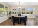 Bright dining room featuring modern light fixture, a round wood table, and cozy seating with views of the landscaped backyard at 4405 W Euclid Ave, Tampa, FL 33629