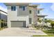 Modern two-story home featuring a gray garage door, stone accents, and well-manicured landscaping at 4405 W Euclid Ave, Tampa, FL 33629