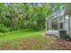 Beautiful backyard showcasing the screened in back porch and mature trees at 5014 Sterling Manor Dr, Tampa, FL 33647