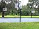 Outdoor basketball court with three hoops, a bench, and lush green surroundings provides recreational opportunities at 5014 Sterling Manor Dr, Tampa, FL 33647