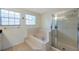 Bathroom with tiled bath, a shower cabin, and natural light at 5014 Sterling Manor Dr, Tampa, FL 33647