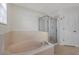 Bathroom features a tiled bath, glass enclosed shower, and neutral paint at 5014 Sterling Manor Dr, Tampa, FL 33647