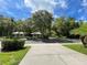 Scenic view of community entrance featuring lush landscaping, mature trees, and charming architectural details at 5014 Sterling Manor Dr, Tampa, FL 33647