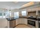 Open kitchen featuring stainless steel appliances, white cabinets, granite countertops, and tile floors throughout at 5014 Sterling Manor Dr, Tampa, FL 33647