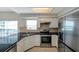 Bright kitchen features granite countertops, stainless steel appliances and modern lighting at 5014 Sterling Manor Dr, Tampa, FL 33647