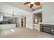 Open-concept living room with a fireplace, ceiling fan, neutral paint, and tile flooring flowing into the kitchen at 5014 Sterling Manor Dr, Tampa, FL 33647