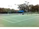 Well-maintained tennis court with lighting and shaded seating area offers a great venue for outdoor sports at 5014 Sterling Manor Dr, Tampa, FL 33647