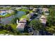 Aerial view of a condo community with a pond, mature trees, parking, and a community pool at 5026 Water Oak Dr # 220, Bradenton, FL 34207