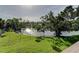 Scenic backyard view featuring a pond, lush greenery, and mature trees at 5026 Water Oak Dr # 220, Bradenton, FL 34207
