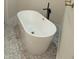 Elegant bathroom featuring a freestanding soaking tub, contemporary fixtures, and stylish patterned flooring at 5166 Deltona Blvd, Spring Hill, FL 34606
