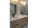 Modern bathroom with double vanity, updated fixtures, and decorative gold framed mirrors at 5166 Deltona Blvd, Spring Hill, FL 34606