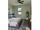 Cozy bedroom with a comfortable bed, soft lighting, sleek ceiling fan, and a view from the window at 5166 Deltona Blvd, Spring Hill, FL 34606