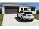 Charming single-story home with a two-car garage and a white car parked in the driveway, enhancing its curb appeal at 5166 Deltona Blvd, Spring Hill, FL 34606