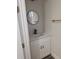 Compact and stylish powder room with a modern vanity, sleek faucet, and a round mirror at 5166 Deltona Blvd, Spring Hill, FL 34606