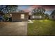 Charming single-story home boasts a lush green lawn, gray exterior, and a concrete driveway at 5208 S 82Nd St, Tampa, FL 33619