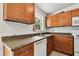 The kitchen features wood cabinets, granite countertops, and a window with outdoor views at 5208 S 82Nd St, Tampa, FL 33619