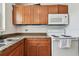 Kitchen with wood cabinets, granite countertops, microwave, and electric range at 5208 S 82Nd St, Tampa, FL 33619