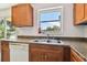 The kitchen features wood cabinets, granite countertops, a dishwasher, and outdoor view at 5208 S 82Nd St, Tampa, FL 33619