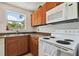 A well-lit kitchen features wood cabinets, granite countertops, microwave, and electric range at 5208 S 82Nd St, Tampa, FL 33619
