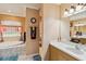 A bright bathroom features a soaking tub, walk-in shower, double vanity, and a large window at 5444 90Th Avenue E Cir, Parrish, FL 34219