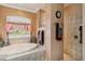 A soaking tub sits beneath a large window in this bathroom with a walk-in shower at 5444 90Th Avenue E Cir, Parrish, FL 34219
