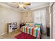 Cozy bedroom featuring a ceiling fan, a colorful striped daybed, and charming decor at 5444 90Th Avenue E Cir, Parrish, FL 34219