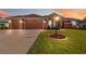 Charming single-story home with manicured lawn, brick driveway, and well-lit exterior showcasing curb appeal at 5444 90Th Avenue E Cir, Parrish, FL 34219