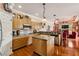 Bright kitchen with stainless appliances, an island, and views into a cozy living space with a fireplace at 5444 90Th Avenue E Cir, Parrish, FL 34219