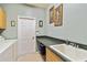 Bright laundry room with sink, ample counter space, and adjacent doorway at 5444 90Th Avenue E Cir, Parrish, FL 34219