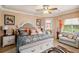 Well-lit main bedroom with an upholstered headboard and sitting area near a bright window at 5444 90Th Avenue E Cir, Parrish, FL 34219